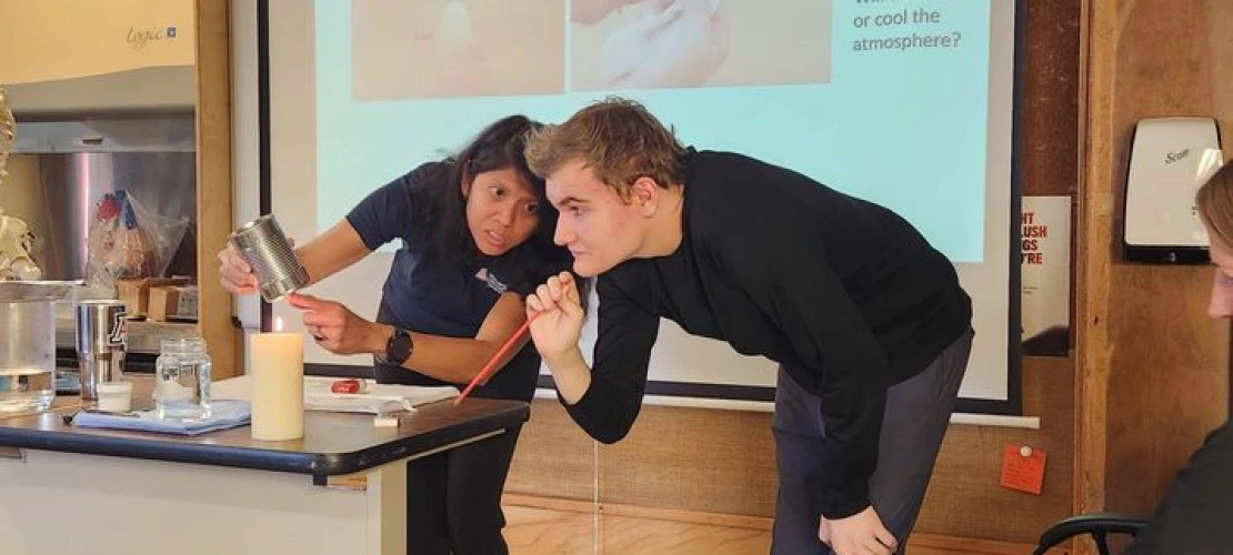 Genie Lorenzo (23-24 Carson Scholar) and Kino School student using a tin can and candle in a hands-on demonstration